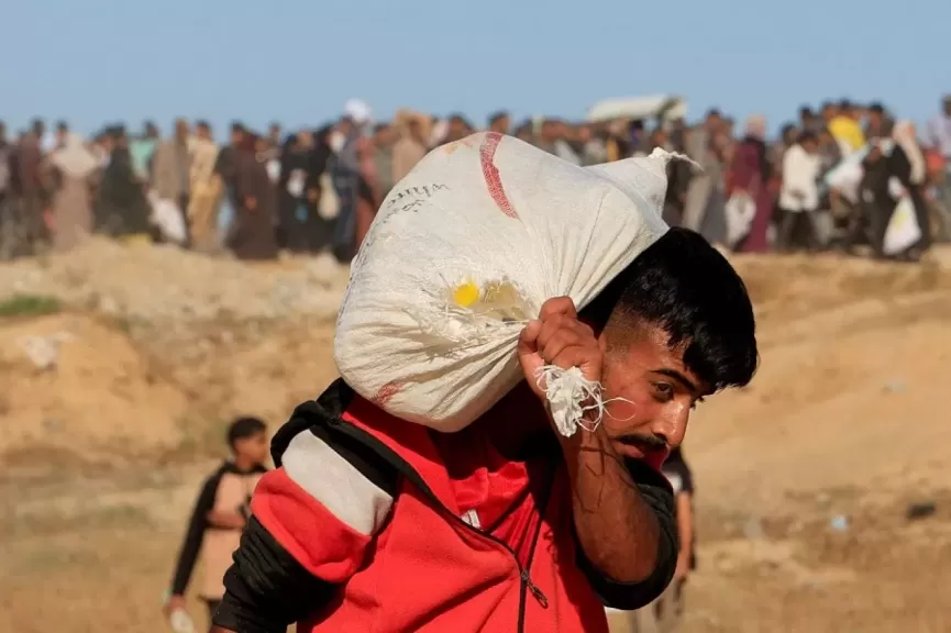 فلسطيني يحمل مساعدات من "مؤسسة غزة الإنسانية" في خان يونس